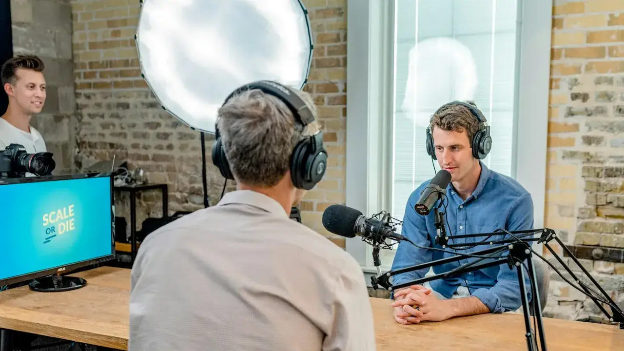 Two hosts recording a podcast at microphones